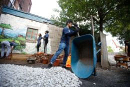 man dumping our white rock from a wheel barrel