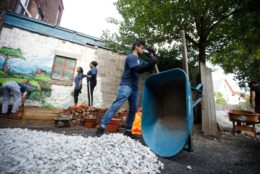 man with wheel barrel working on court yard and white stone