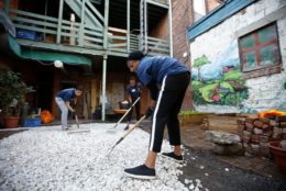 group working on laying white stone in courtyard