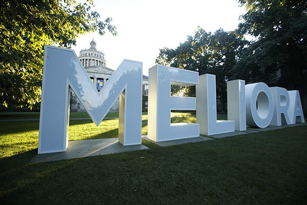 Meliora sign in front of Rush Rees library