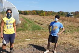 two men in masks out in a field