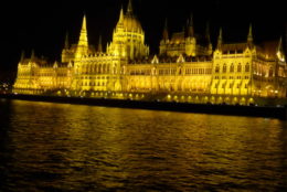 large palace light up at night in front of water