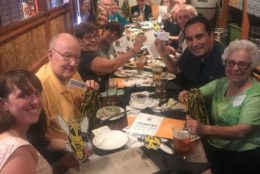 group of people at dinner table posing for photo