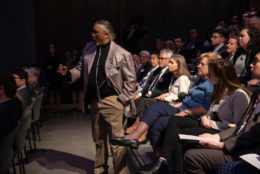 man standing asking a question in audience