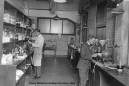 black/white photo with two men working in pharmacy from 1926