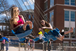 two women on swings carnival ride on a sunny day