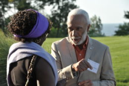 man facing a woman having a chat outdoors in front of grass field