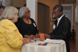 two women and one man in a conversation around a high table