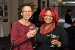 two women holding a drink smiling for photo