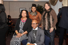 three women and one man posing for photo