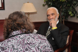 man sitting facing a woman in a discussion