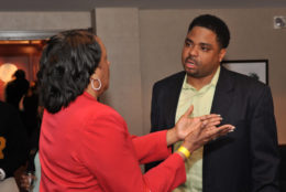 man speaking to a woman wearing a red coat