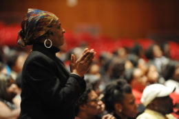 Woman standing in crowd clapping