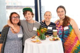 four people smiling for photo at a high top table