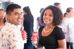 man and woman holding a red can smiling for the camera