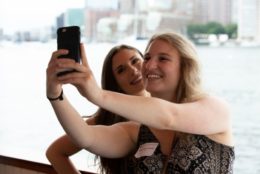 two women taking selfie in front of water front in boston