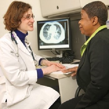 a female doctor speaks to a patient within an office.