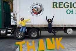 two people jumping by a truck with 'thank you' letters in yellow