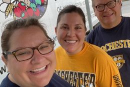 two women and a man in UR shirts smiling for photo at the regional food bank