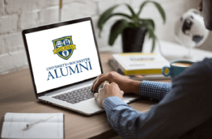 laptop open with the university of rochester alumni logo on the screen