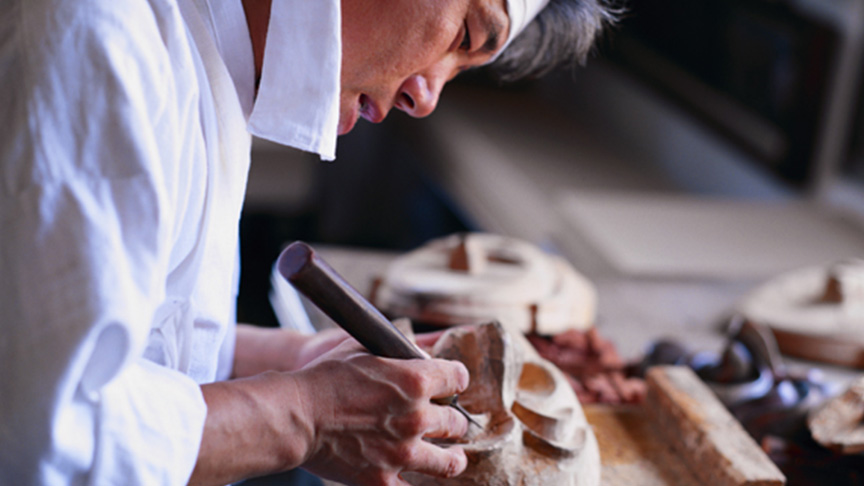 Man carving a wooden mask