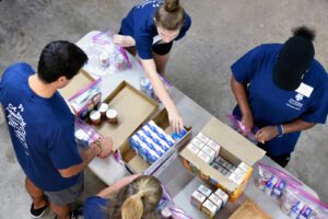 University of Rochester alumni and their families assemble food packages at Baltimore Hunger Project
