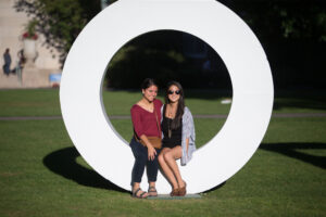 2 girls sitting in the letter "o" posing for the camera