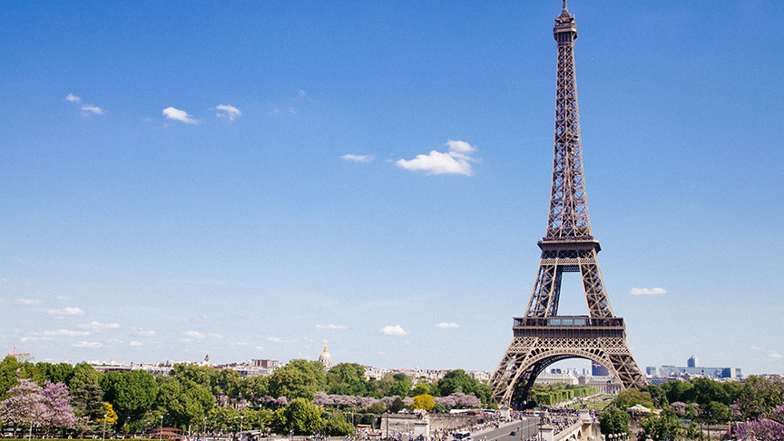 Eiffle tower with trees, and street in foreground