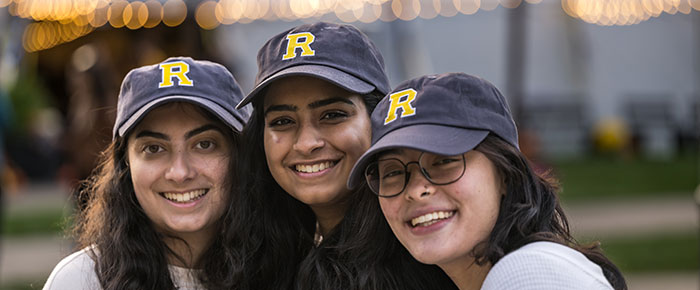 Three women smile and posing for a photo.