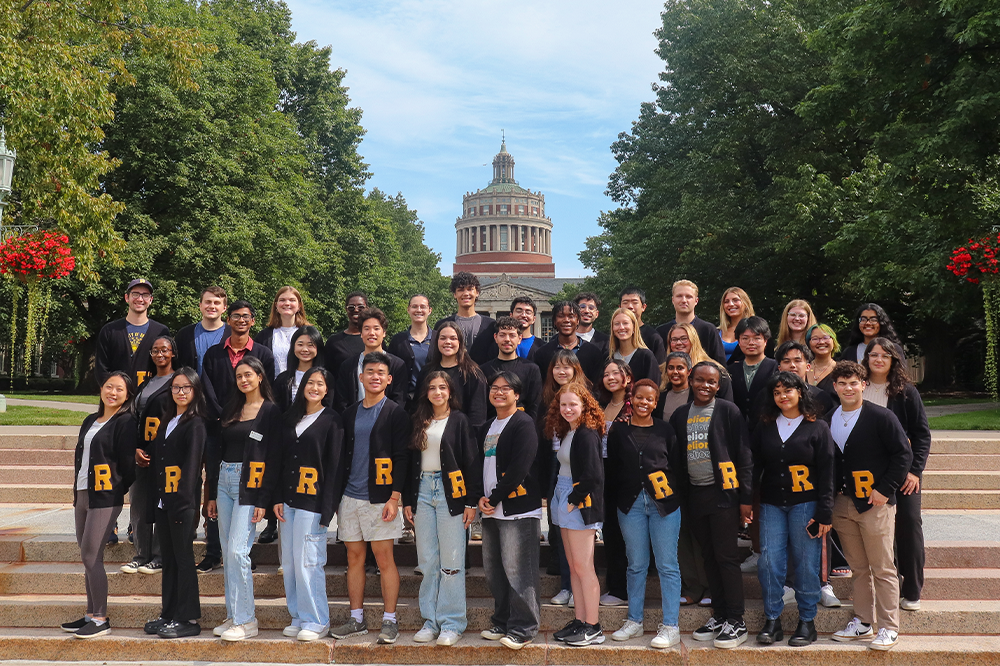 Group photo of student alumni ambassadors in the quad, with Rush Rhees library tower in background
