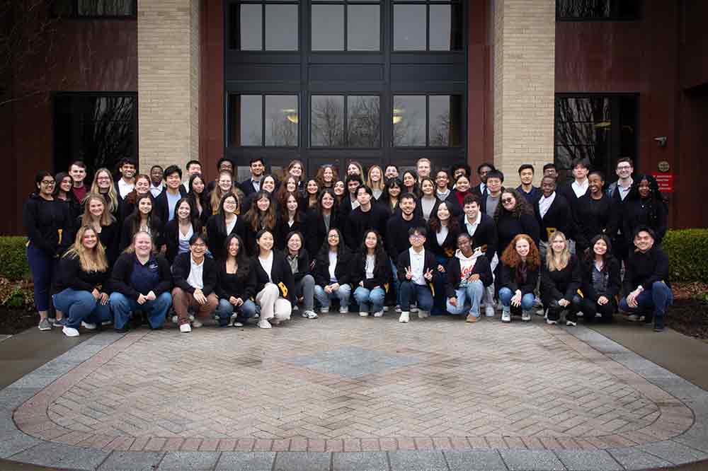 Group photo of student alumni ambassadors in front of a building