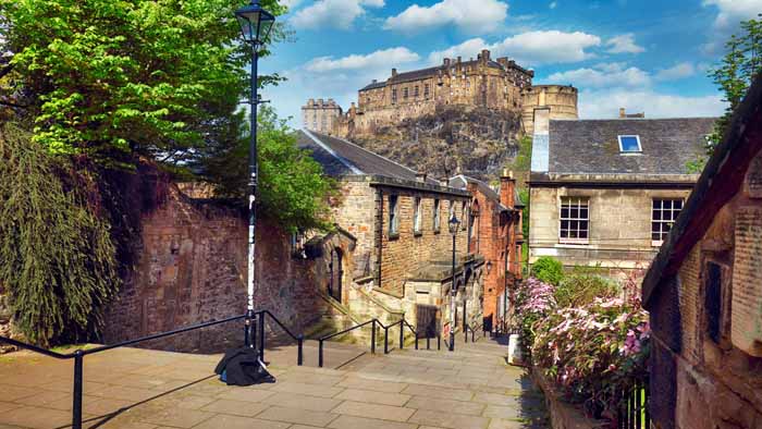 Edinburgh castle with Vennel street, Scotland - nobody Edinburgh castle in Scotland looming in the background, with stone building in the midground, and stone stairs in the foreground