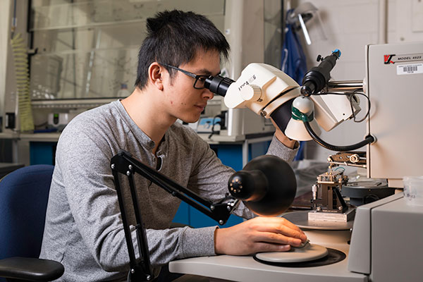 A student looking into a microscope.