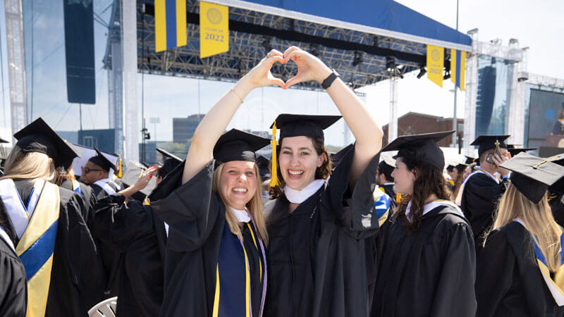 Students toss their graduation caps in the air at University of Rochester