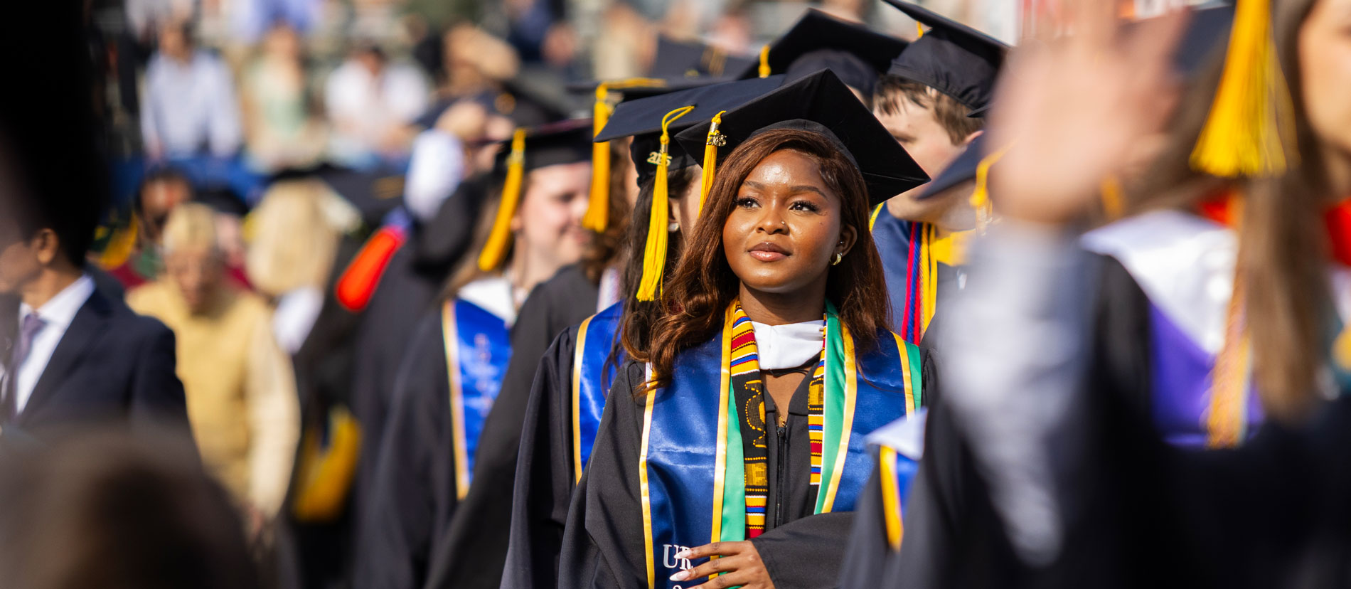 Two women in graduation gowns smiling and taking a selfie during the University of Rochester Commencement Weekend.