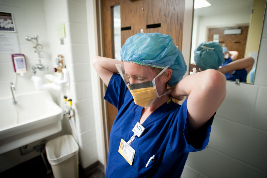 Medical resident putting on mask at University of Rochester Medical Center
