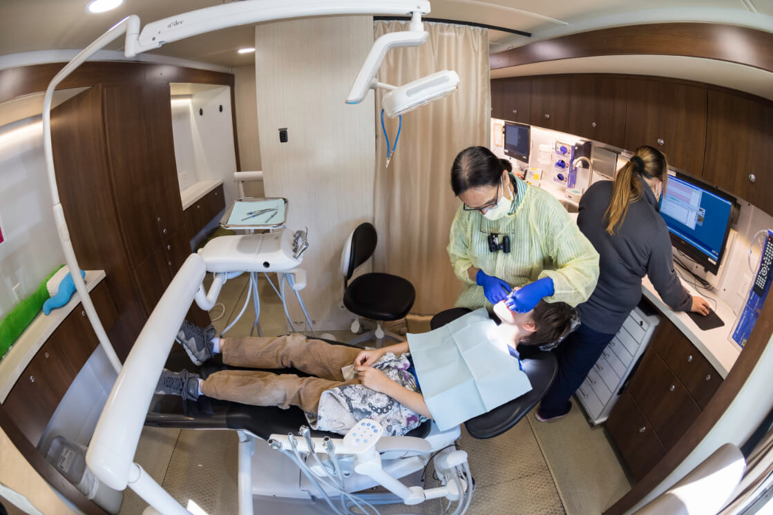 Local student getting dental check-up in SmileMobile as part of URMC community outreach