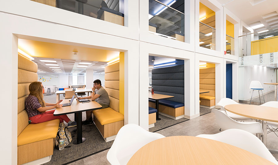 Two students studying at a table in a library at the University of Rochester