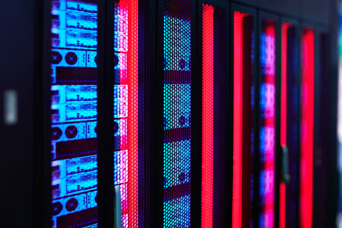A row of servers illuminated by red and blue lights, showcasing a high-tech data center environment.