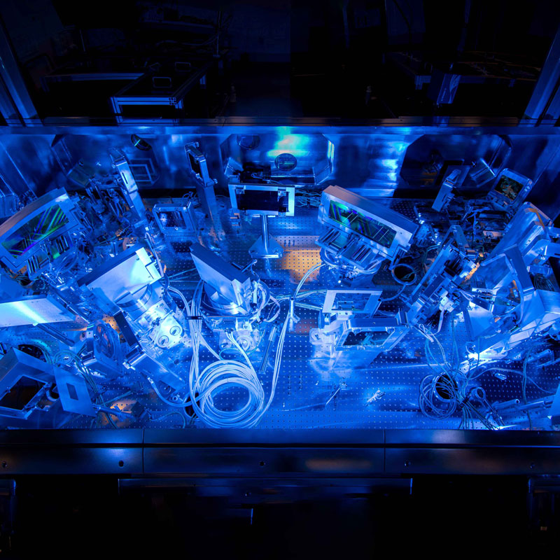 A blue light illuminates a machine at the University of Rochester’s Laboratory for Laser Energetics.