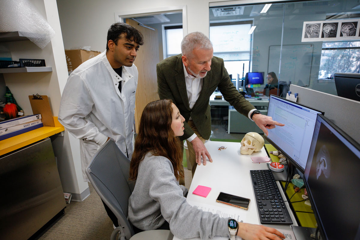Two individuals, a man and a woman, observe a computer screen together at the University of Rochester.
