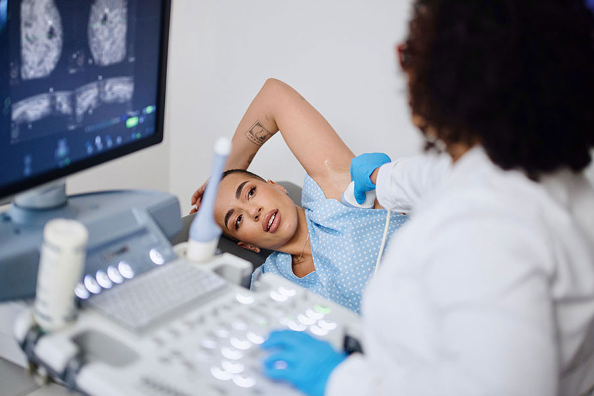 A woman receiving an ultrasound on her arm at the University of Rochester health care facility.