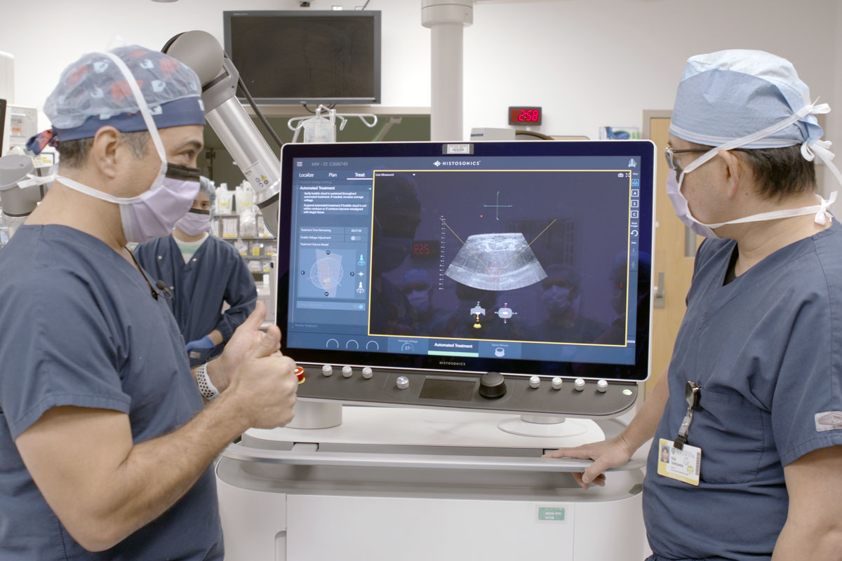 Two doctors in scrubs examine a computer screen at the University of Rochester Medical Center.