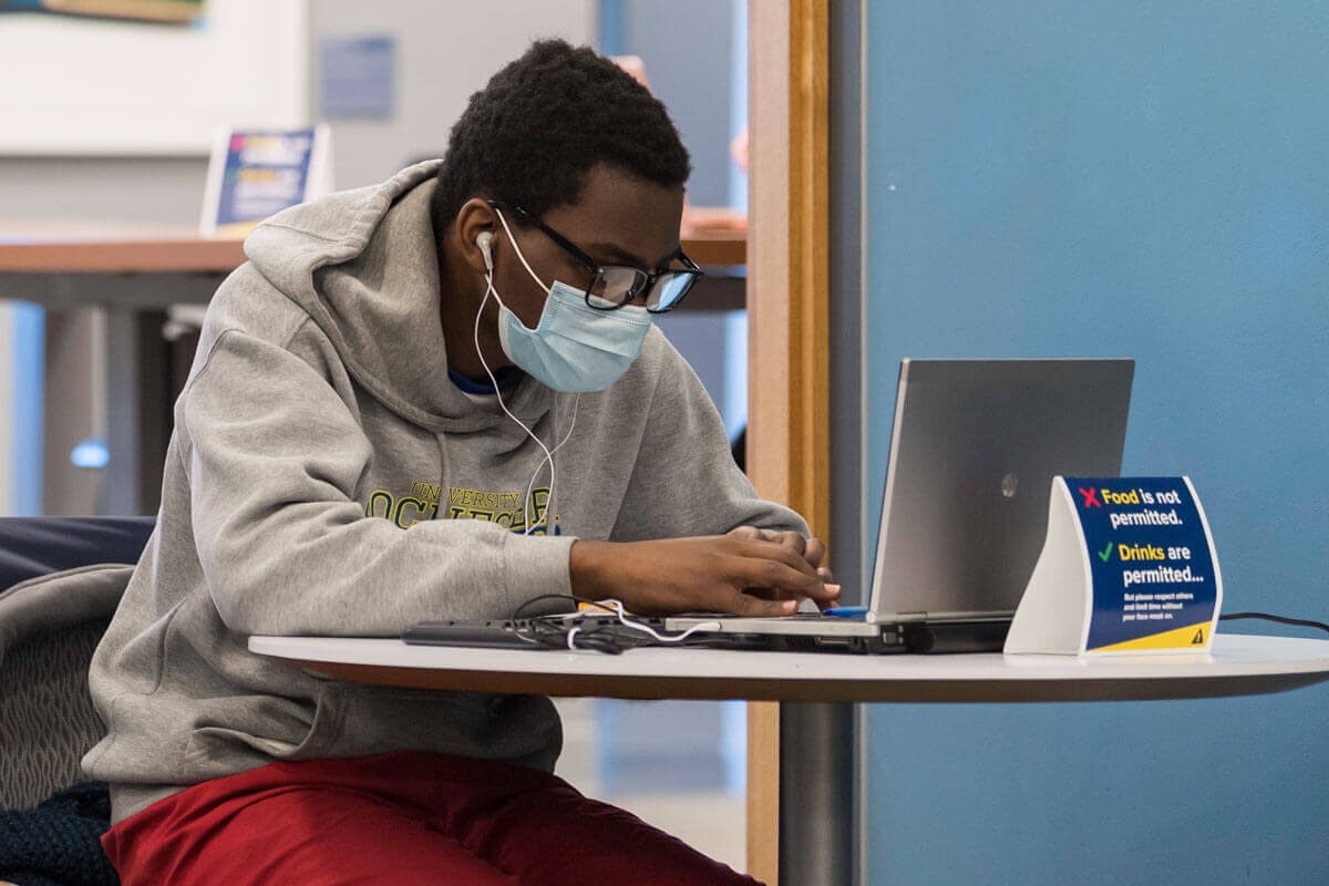 Student wears mask while studying at the University of Rochester.