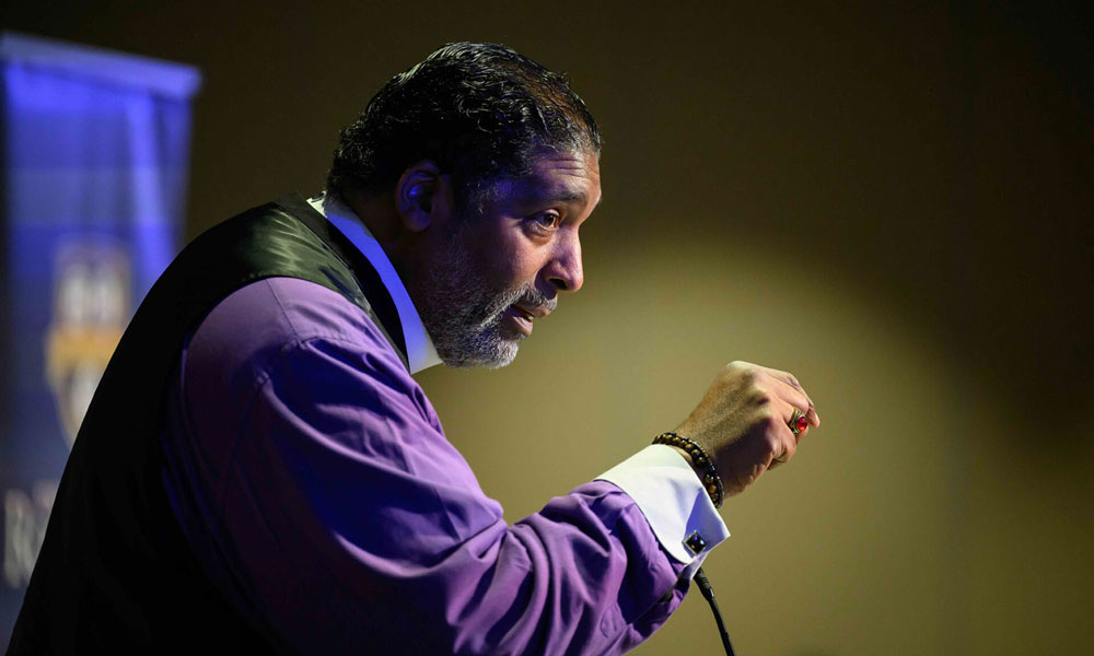 The Rev. Dr. William J. Barber II seen in side profile while speaking at a podium during the 2026 Martin Luther King Junior Address at URochester.