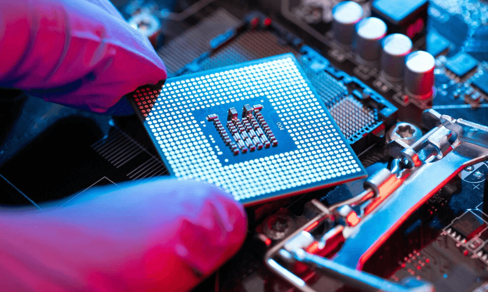 A gloved hand holds a computer processor chip
