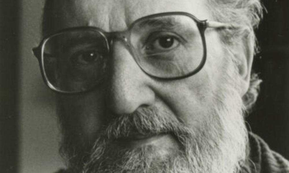 Carl Chiarenza, a noted photographer and art educator, poses in front of a camera.