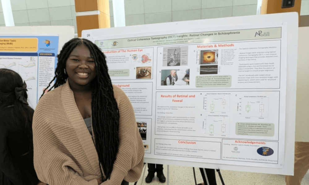 student with poster at scientific presentation