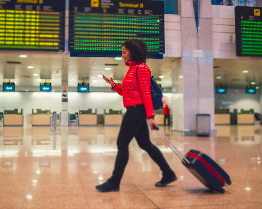 Student in airport with briefcase and cell phone