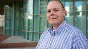 Mark Bocko Photo Standing Outside in front of Glass